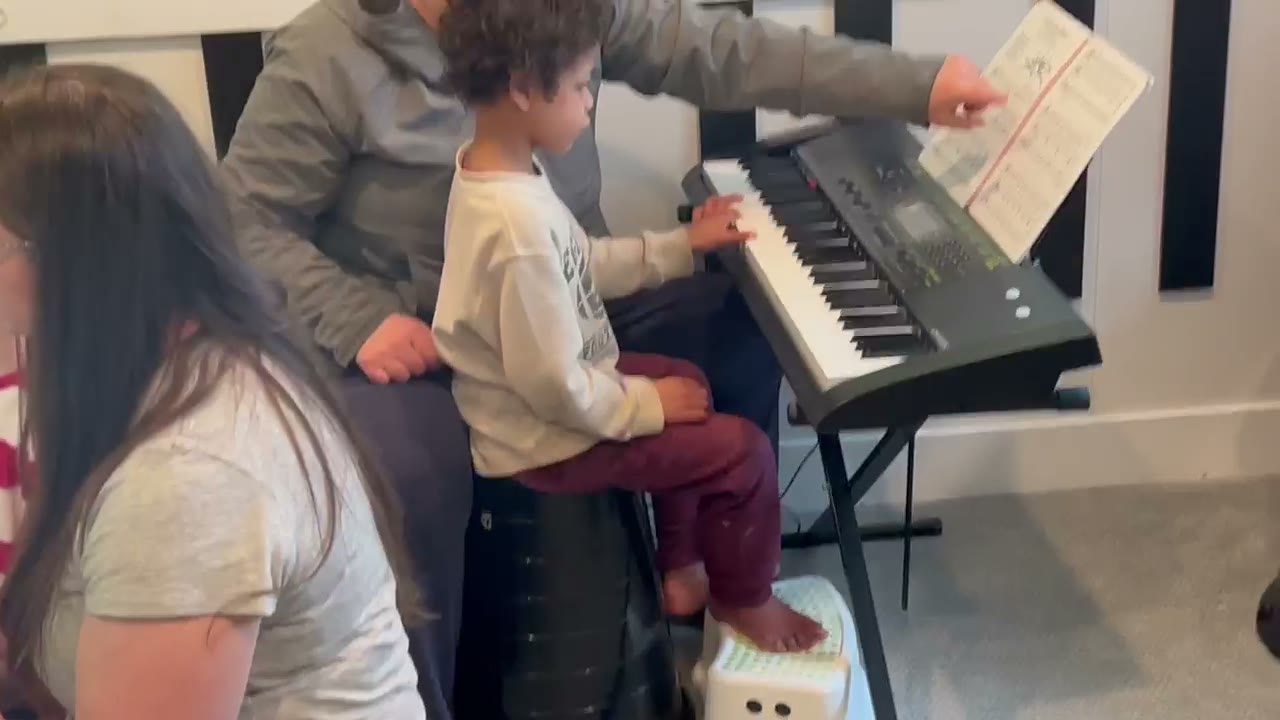 Children working with teachers at keyboards